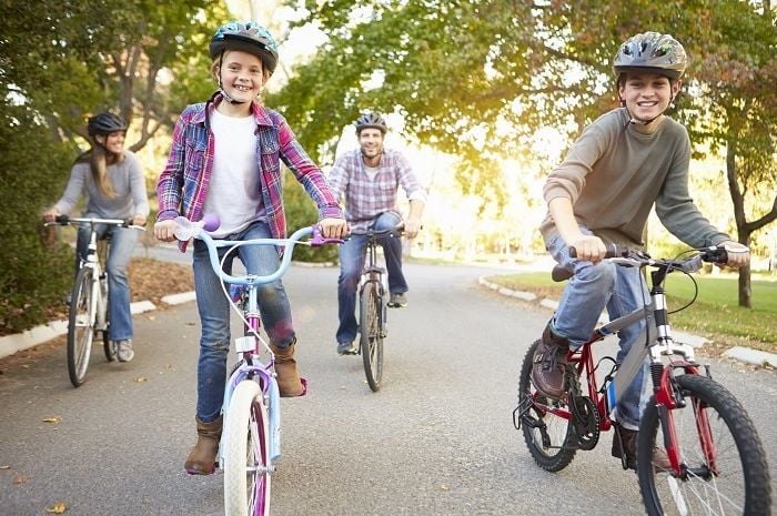 family riding bikes on a public trail